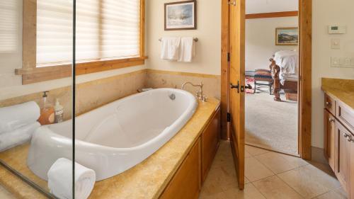 a bath tub in a bathroom with a window at Ski in Ski out 4 Bedroom Spruce Peak Lodge Luxury Mountain Cabin By Stowe Mountain Rentals in Stowe