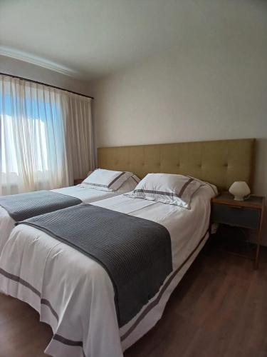 Un dormitorio con dos camas y una ventana. en Alvear Suites, en Esquel
