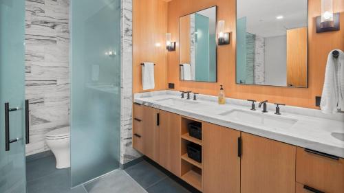 a bathroom with two sinks and a toilet at 4F One Spruce Peak Stowe Mountain Resort Ski in Ski Out 4 bed Sleeps 10 in Stowe