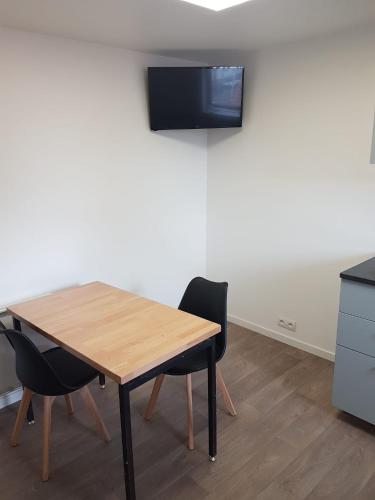 d'une table avec deux chaises et d'une télévision murale. dans l'établissement 2D app à neuf Tout équipé, à Tourcoing