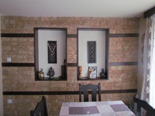 a dining room with two mirrors on a brick wall at Guest House Raffe in Dobrinishte