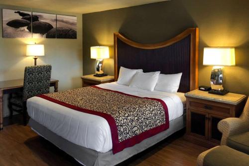 a hotel room with a large bed and two lamps at The INN ON 66 in Flagstaff