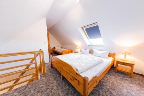 a bedroom with a wooden bed and a staircase at Gasthaus Deichkieker - Wo die Nordsee dich umarmt und Erholung beginnt in Horumersiel