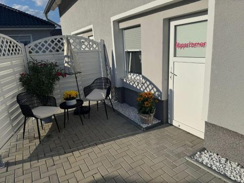 a patio with two chairs and a table and a door at Ferienwohnungen AugenBlick Naumburg in Eulau