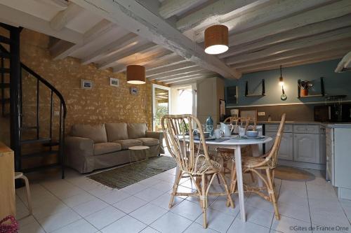 une cuisine et un salon avec une table et des chaises dans l'établissement Gîte rural Sainte-Eugénie, à Gouffern en Auge