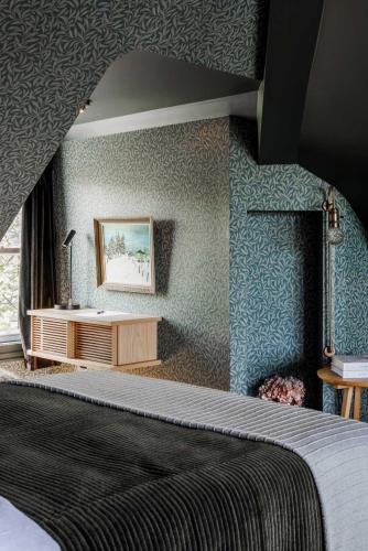 a bedroom with a bed and a desk in a room at Dvele Inn in St. John's