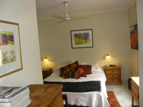 a bedroom with a bed and two tables and a fan at El Descanso - SilHouse Nerja in Nerja