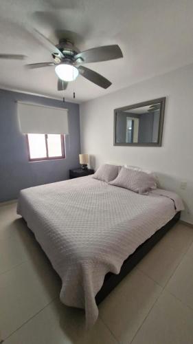 a bedroom with a bed with a ceiling fan at Tranquilidad cerca del mar in Bucerías