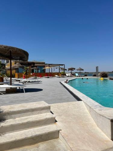 a swimming pool at a resort with blue water at 818 Centro Náutico Bungalows in Vila Real de Santo António