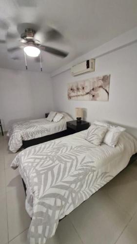 a bedroom with two beds and a ceiling fan at Tranquilidad cerca del mar in Bucerías