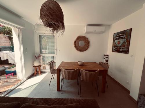 une salle à manger avec une table et des chaises en bois dans l'établissement Maison à Lacanau Océan, à Lacanau-Océan