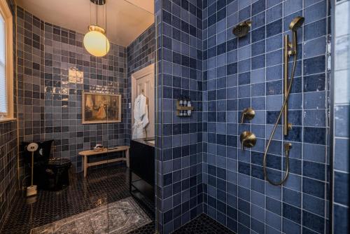 a blue tiled bathroom with a shower at Dvele Inn in St. John's