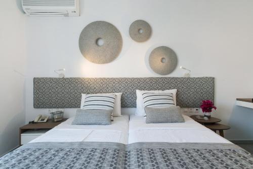 a bedroom with a large bed with two pillows at Aurora - Rooms & Suites - Spetses in Spetses