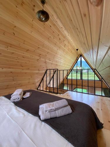 a bedroom with a bed in a wooden room at Kamara Cottages in Kazbegi