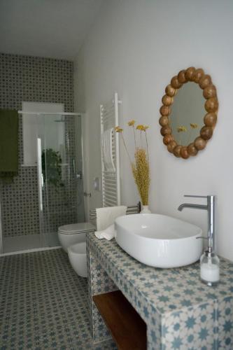 a bathroom with a sink and a toilet and a mirror at Lilium Maison in Canosa Sannita