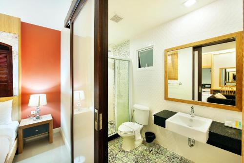 a bathroom with a toilet and a sink and a mirror at Ratana Hotel Rassada - SHA Extra Plus in Phuket Town