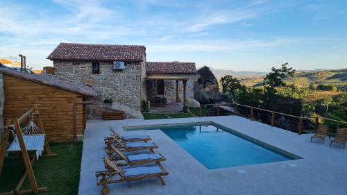 a house with a swimming pool next to a building at Casa do Bó Nel in Valpaços