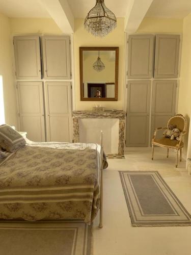 a bedroom with a bed and a mirror and a chair at Bastide Bellevue in Gaudonville