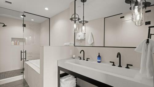 a white bathroom with a sink and a mirror at New Spruce Peak Tree House Unit Steps To The Lifts With Big Mountain Views Sleeps 9 By Stowe Mountain Rentals in Stowe