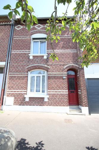 un bâtiment en briques rouges avec une porte rouge dans l'établissement Grande maison de ville 8 places, à Amiens