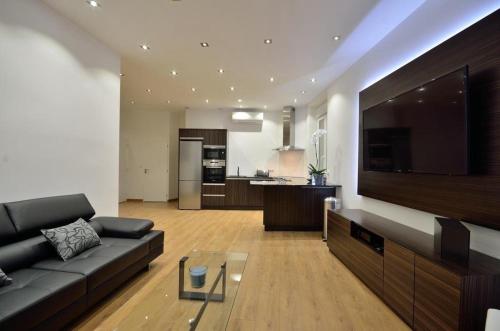 - un salon avec un canapé et une grande télévision dans l'établissement Superbe appartement, à Cannes