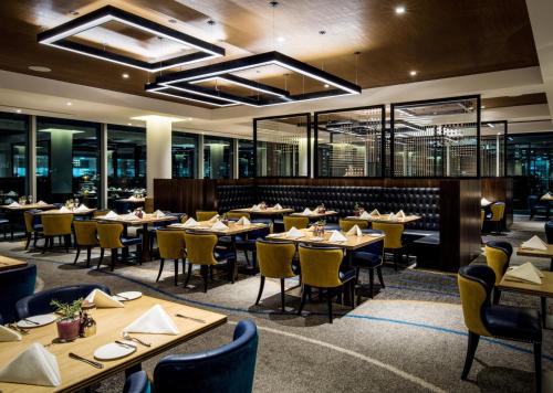 a dining room with tables and chairs and windows at InterContinental London - The O2 in London