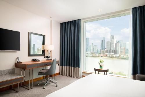 a hotel room with a desk and a large window at InterContinental London - The O2 in London