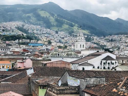 Una vista de una ciudad con montañas al fondo. en George House, en Quito