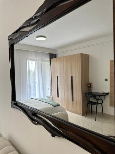 a mirror reflecting a bedroom with a bed and a desk at Executive studio- Limuru Road Ruaka in Ruaka