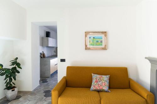 a living room with a yellow couch and a kitchen at Appartamento Lìelà in Millesimo