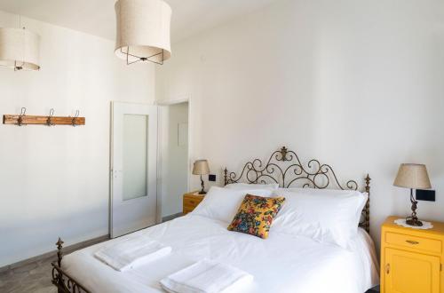 a bedroom with a white bed and a mirror at Appartamento Lìelà in Millesimo