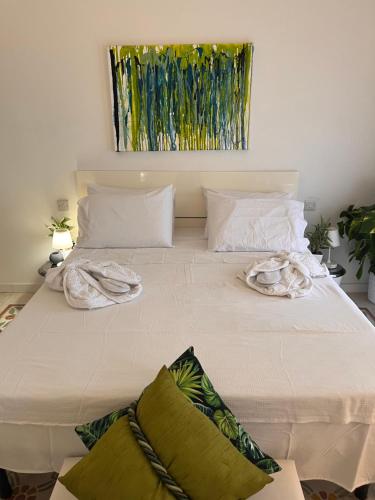 a large white bed with two towels on it at Cozy, modern and welcoming in Il-Ħamra