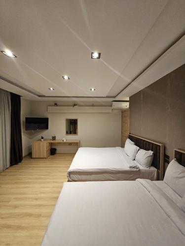 a hotel room with two beds and a television at Palm Pyramids View INN in Cairo