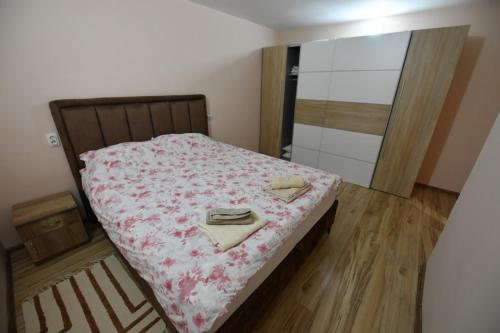 a small bedroom with a bed with a pink blanket at Apartman Poezija in Bajina Bašta
