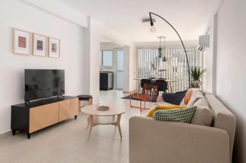 a living room with a couch and a tv at Amazing Two Bedroom Apartment in Larnaca