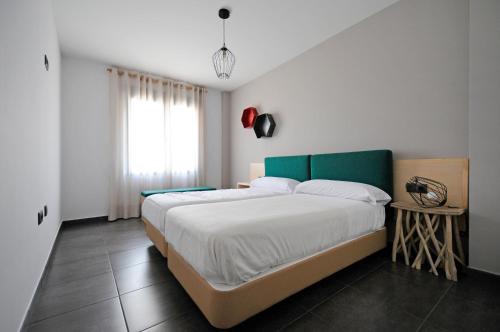 a bedroom with a large bed with a green headboard at La Fábrica de Pan in Coca