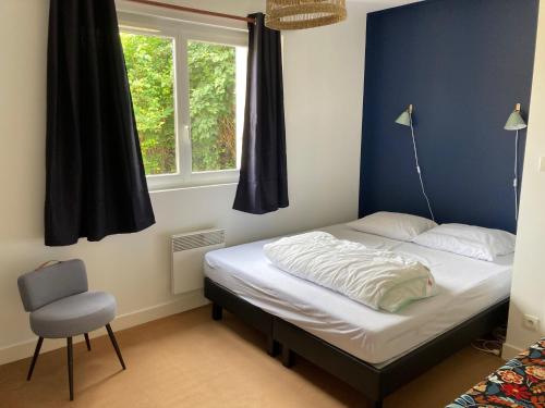 une chambre avec un lit, une chaise et une fenêtre dans l'établissement La Maison Siméon, à Amboise