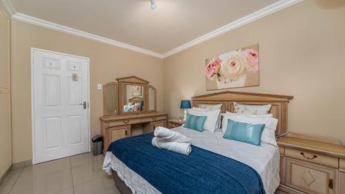 a bedroom with a bed with blue and white pillows at 10 Malibu, Beverly Hills Estate in Ballito