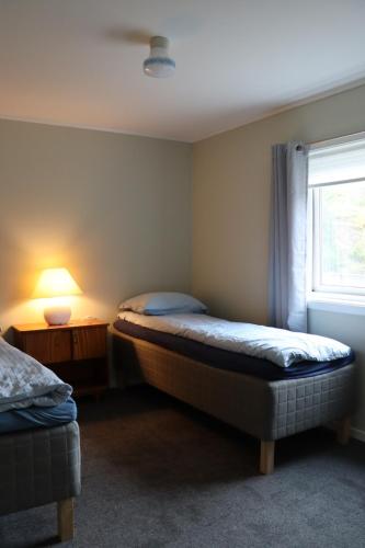 a bedroom with two beds and a window at Gammelbutikken Guesthouse in Pettvik