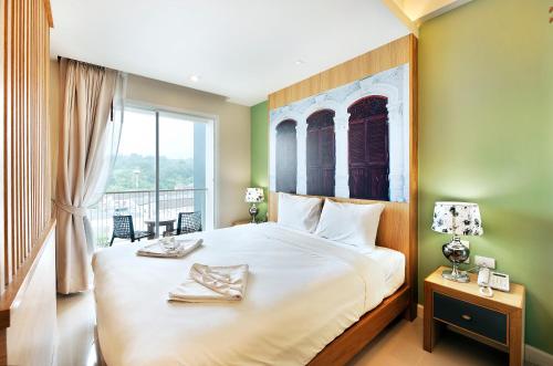 Ratana Hotel Rassada - SHA Extra Plus tesisinde bir odada yatak veya yataklar