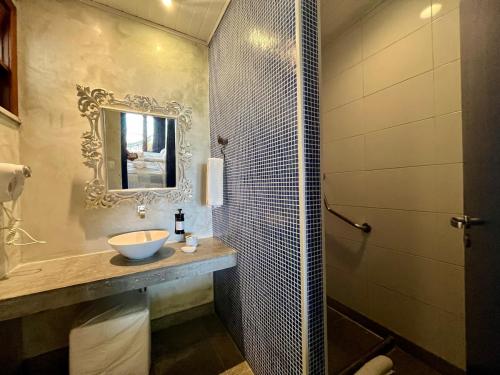 a bathroom with a sink and a shower at Pousada a Capela in Arembepe