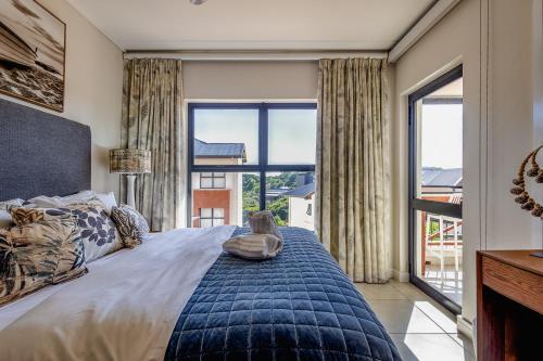 a bedroom with a large bed with a large window at 427 Ballito Hills - Lovely 3 bedroom apartment in Ballito