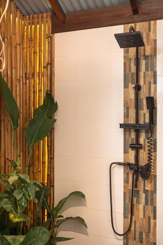 a shower in a bathroom with a wall at Soffta Surf Ranch in General Luna