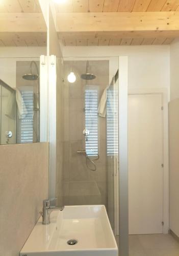 a bathroom with a sink and a shower with a mirror at Il Punto Fermo in Fermo