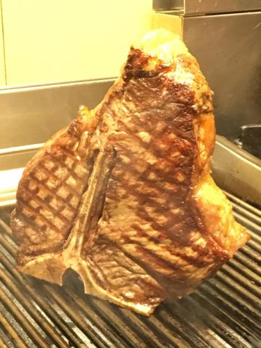 a piece of meat is cooking on a grill at Agriturismo Corte Marani in Badia Calavena