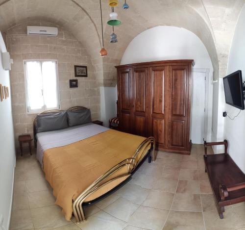 een slaapkamer met een bed en een tv in een kamer bij Casa Vacanze Le Ceramiche in Grottaglie