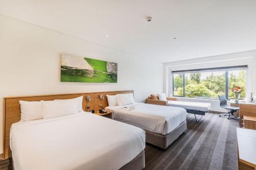 a hotel room with two beds and a window at Crowne Plaza Canberra by IHG in Canberra