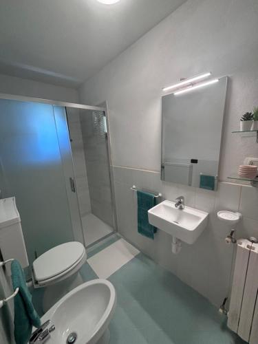 a bathroom with two toilets and a sink and a shower at Casa Zara - cozy home in the heart of Barga in Barga