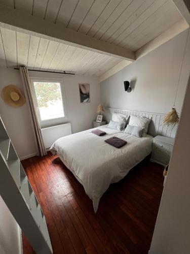 une chambre avec un grand lit et une fenêtre dans l'établissement Maison 3 chambres, terrasse et piscine, à Bretignolles-sur-Mer