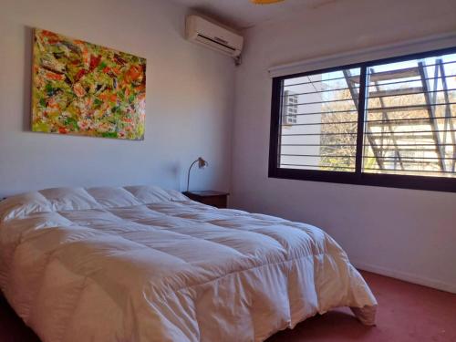 ein Schlafzimmer mit großem Bett und Fenster in der Unterkunft Casa San Isidro pileta jardín parrilla a metros del río in San Isidro